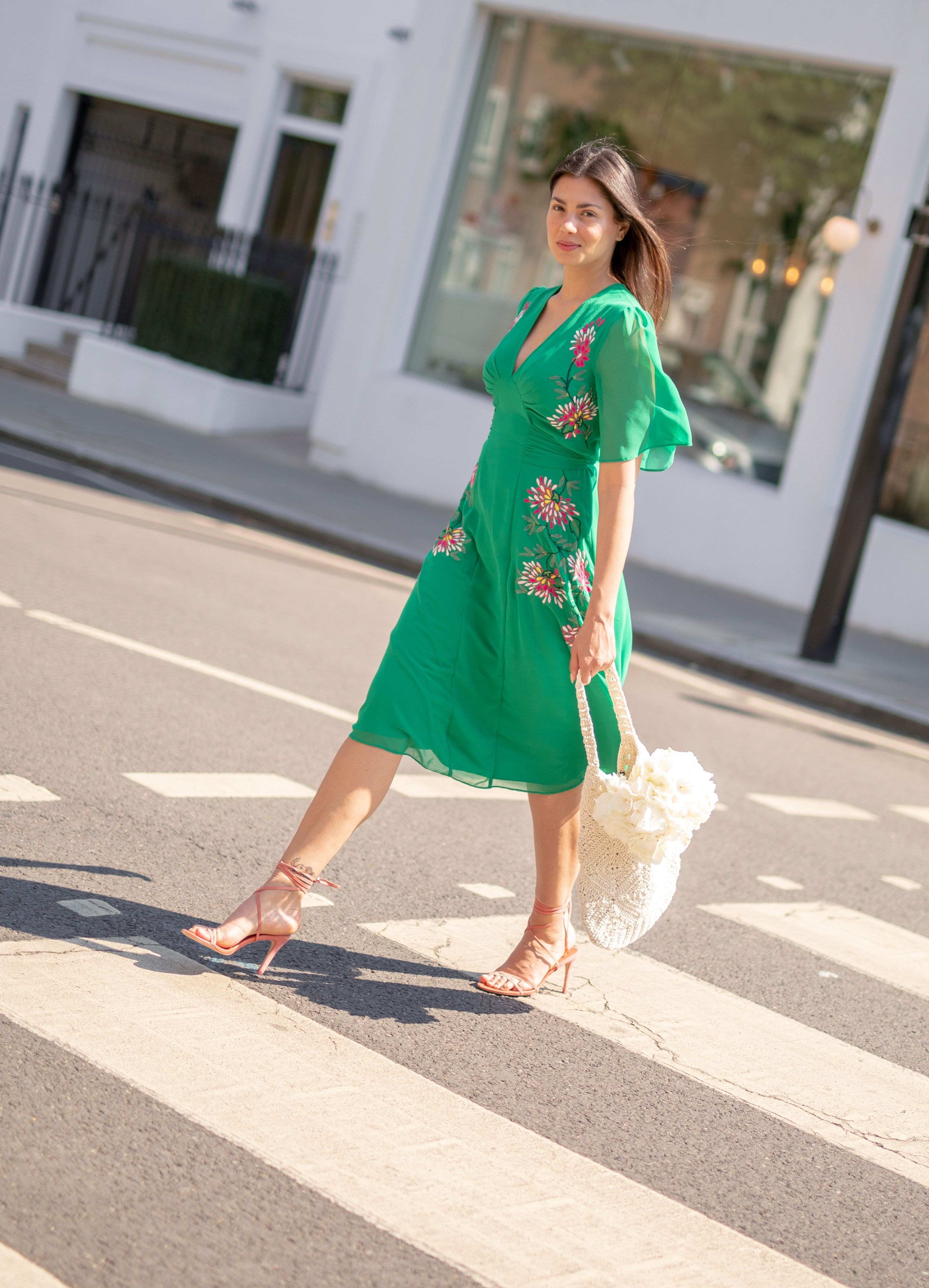 woman wearing green summer dress walking